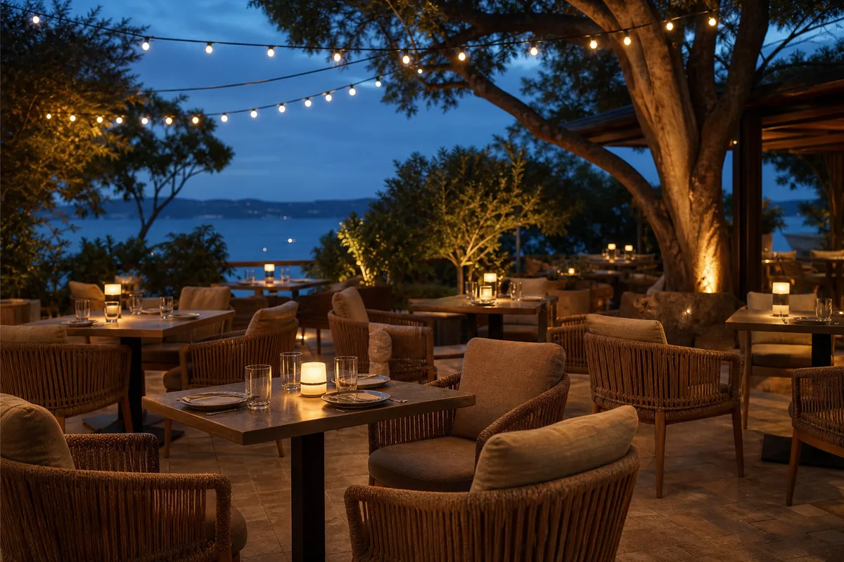 Chaises de terrasse haut de gamme en résine tressée autour de tables dressées au coucher du soleil