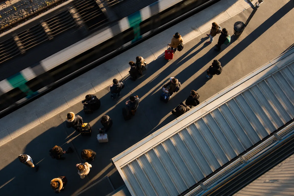 Vue aérienne d’une gare RER avec passagers et bagages en attente